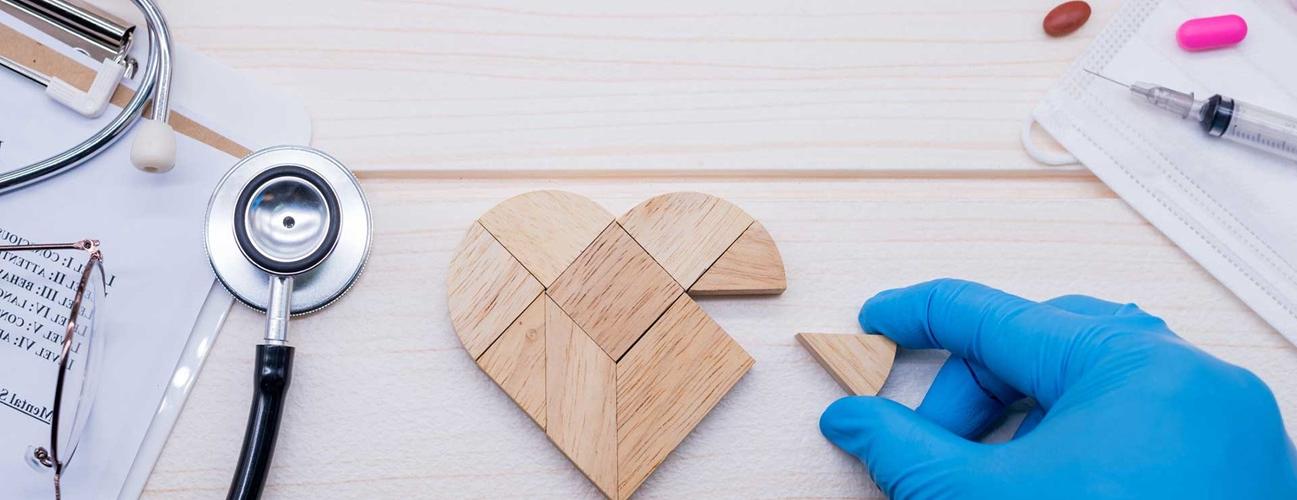 A doctor putting together a wooden heart-shaped puzzle