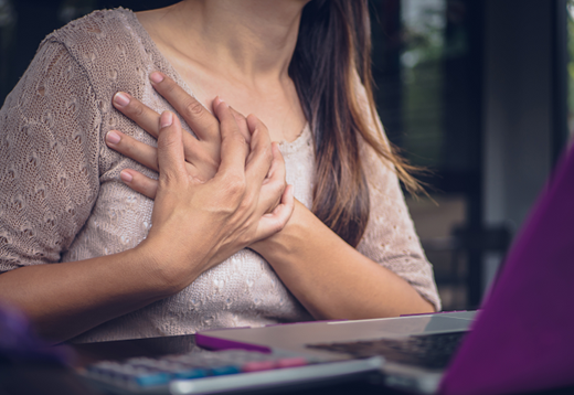A woman clutches her chest in pain.