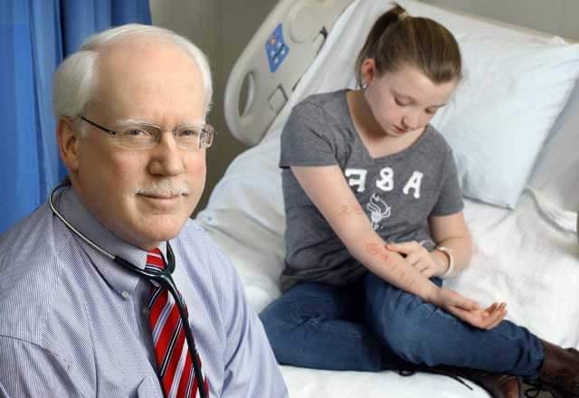 Dr. 罗伯特·伍德和他的儿科过敏推荐十大正规网赌平台在医院病房里，她看着自己手臂上的过敏测试结果